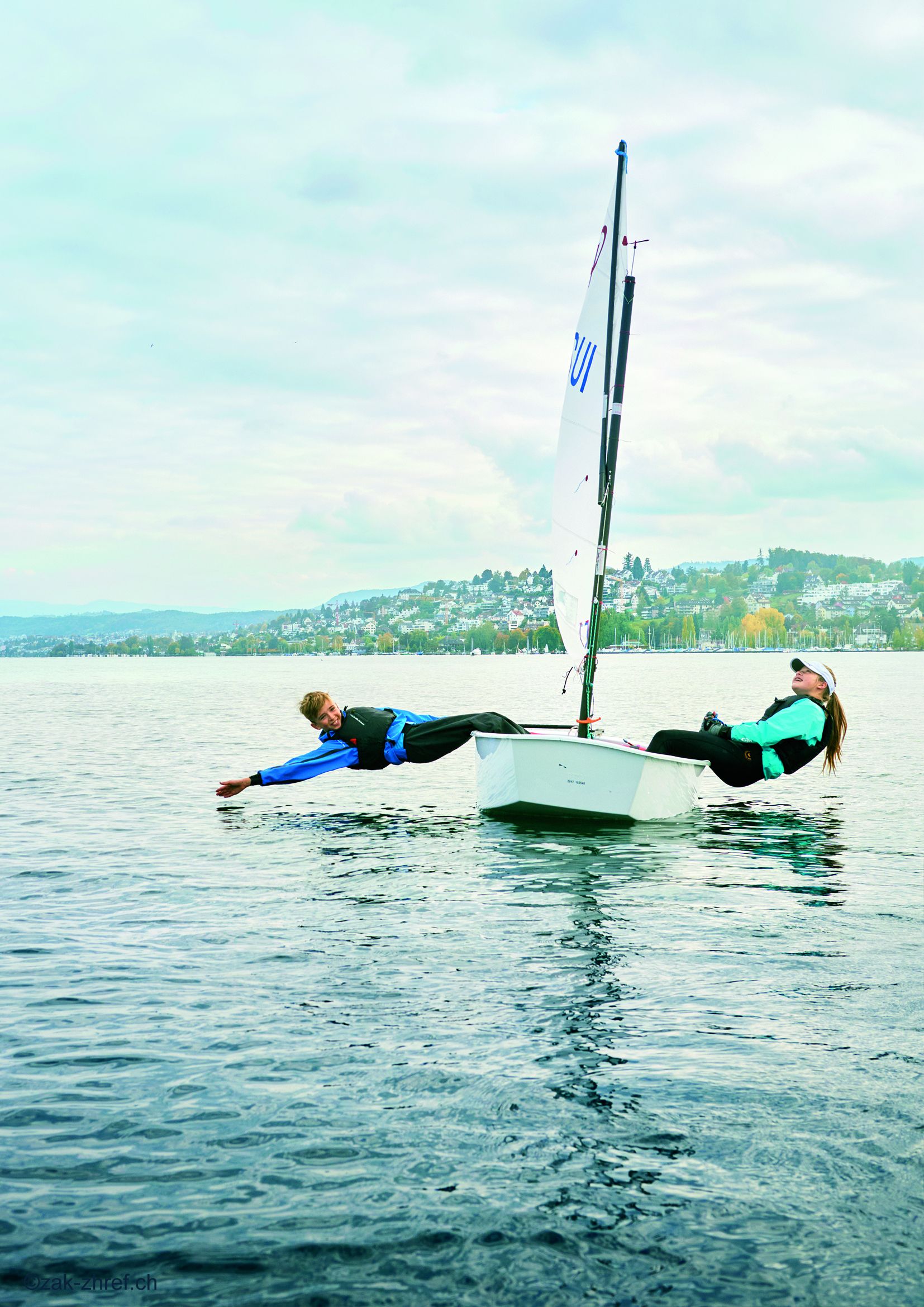 Junge und Mädchen lehnen sich aus einem Boot